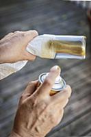 Spraying a glass bottle with gold paint