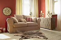 Beige sofa and wicker trunk in living room with re