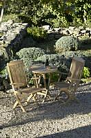 Wooden garden furniture in seating area of Mediter