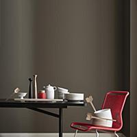 Crockery on black table and red chair in front of 