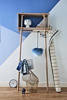 Ornaments on wooden shelving against blue wall