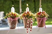 Candles and crab apples arranged in plant pots