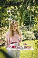 Woman stood next to cakes on DIY suspended table i