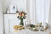 Vase of colourful flowers on table set for Easter 