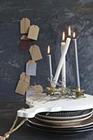 Lot candles on stacked crockery in front of gift t