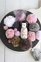 Geisha figurine and pompoms in pink and earthy ton