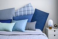 Cushions in shades of blue on double bed and bedsi