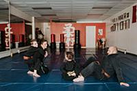 Coaches and students resting in martial arts studi