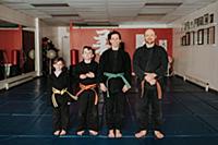 Coaches and students posing in martial arts studio