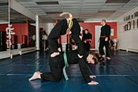 Coach and students practising martial arts in stud