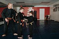 Coach and students practising martial arts in stud