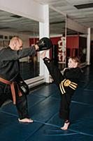 Coach and student practising kickboxing in studio