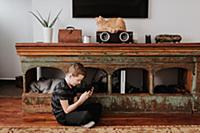 Boy playing with smartphone on floor