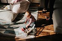 Baby boy sitting on living room floor playing with