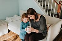 Female toddler and mother looking at coffee cup on