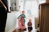 Female toddler and baby brother in kitchen with fa