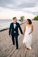 Romantic bride and groom strolling hand in hand on