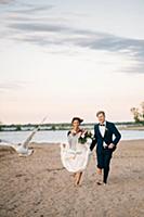 Romantic bride and groom running barefoot on lakes