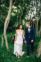 Romantic bride and groom strolling in forest