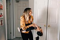 Girl's mother carrying and tickling her in living 