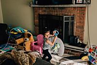 Girl laughing while playing with toy in living roo