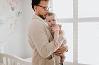 Father with baby daughter in baby's room