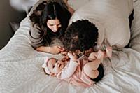 Couple with baby daughter on bed in bedroom