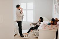 Couple with baby daughter in baby's room