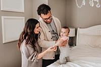 Couple with baby daughter on bed in bedroom