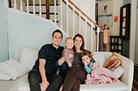 Mid adult couple on sofa with baby son and toddler