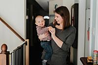 Mother carrying baby son in arms, portrait