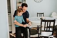 Father putting socks on toddler daughter