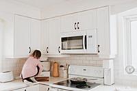 Girl tidying bread bin on kitchen worktop