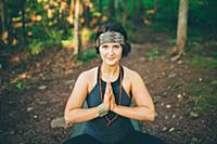 Woman doing prayer pose in forest