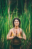 Woman doing prayer pose in forest