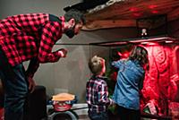 Father and children looking after animal tank
