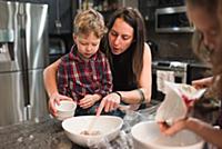 Children helping mother in kitchen