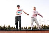 Boy and sister dancing on top of rural wooden stru