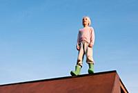 Boy standing on top of skateboard ramp against blu