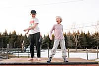 Boy and sister dancing on top of rural concrete sl