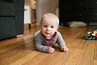 Baby boy crawling on wooden floor