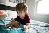Boy counting coins on bed