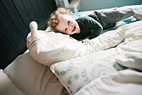 Boy smiling and playing on bed
