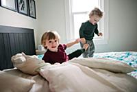 Brothers playing in bed