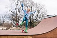 Boy on rural skateboard ramp practicing skateboard