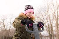 Girl in knit hat laughing on playground equipment