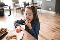Little girl eating freshly baked vegetarian seed b