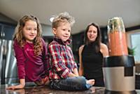Mother and children watching blender making smooth