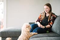 Woman watching dog from sofa