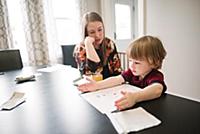 Mother watching over son learning at table